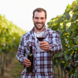 Glass Of Red Wine In Hand, The Young Winemakers In The Vineyard